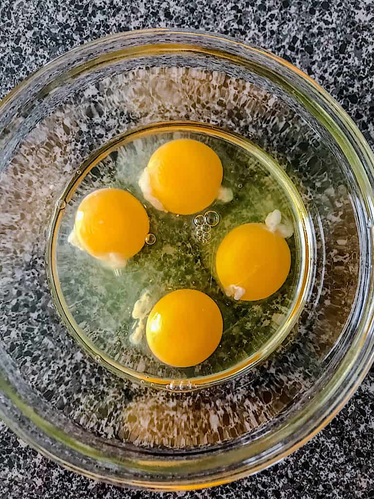 Begin by cracking the eggs into a mixing bowl.