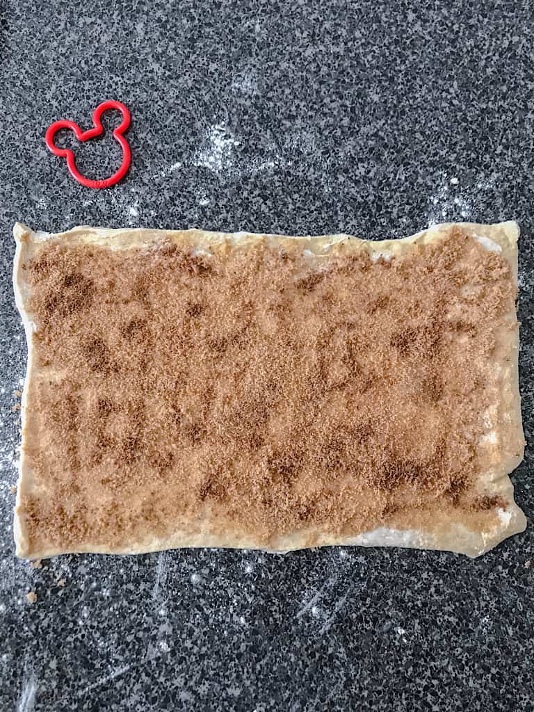 Top each of the crescent dough rectangles with 1 teaspoon of cinnamon each.