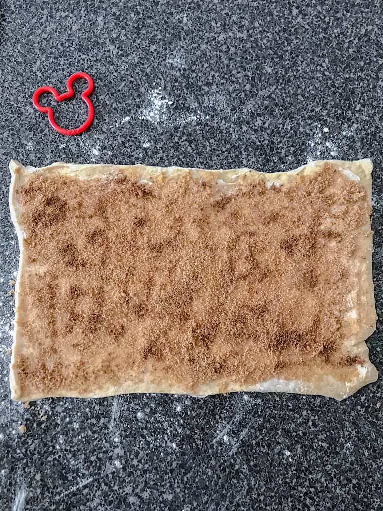 Top each of the crescent dough rectangles with 1 teaspoon of cinnamon each.