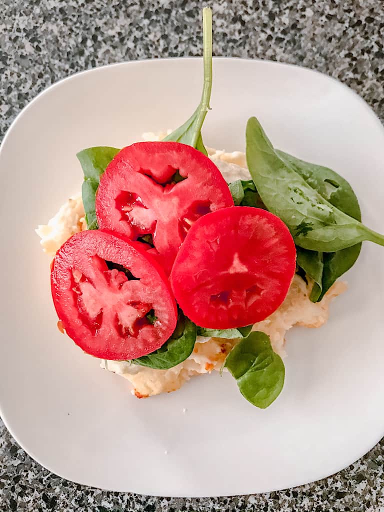 Add 2 or 3 tomato slices on top of the spinach.