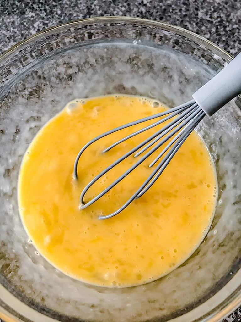 Use a whisk to beat the eggs together and combine the yolks with the egg whites.