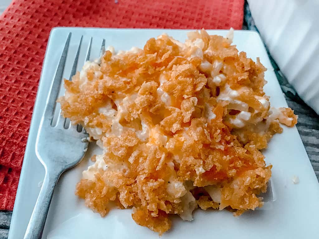 A plate of Funeral Potatoes Casserole and a fork.