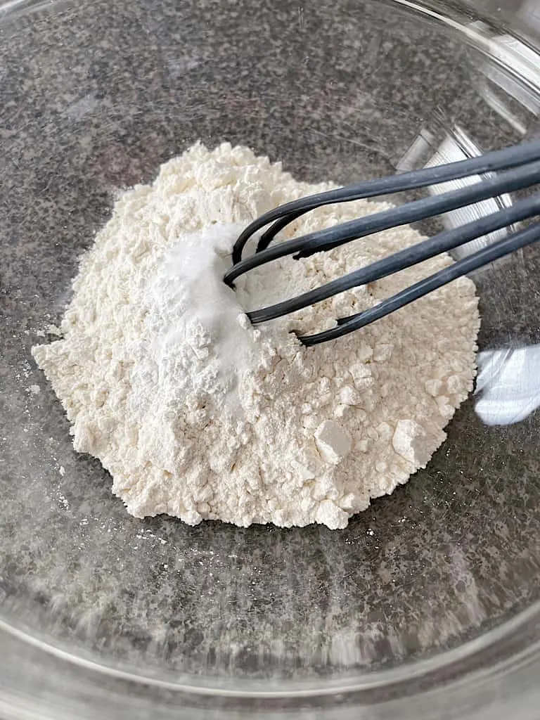 In a mixing bowl, whisk together the flour, baking powder, and salt. Set aside.