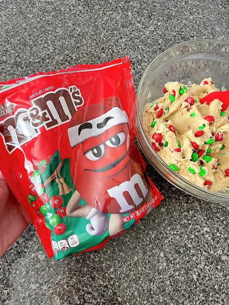 A bag of Christmas M&Ms and cream cheese cookie dough