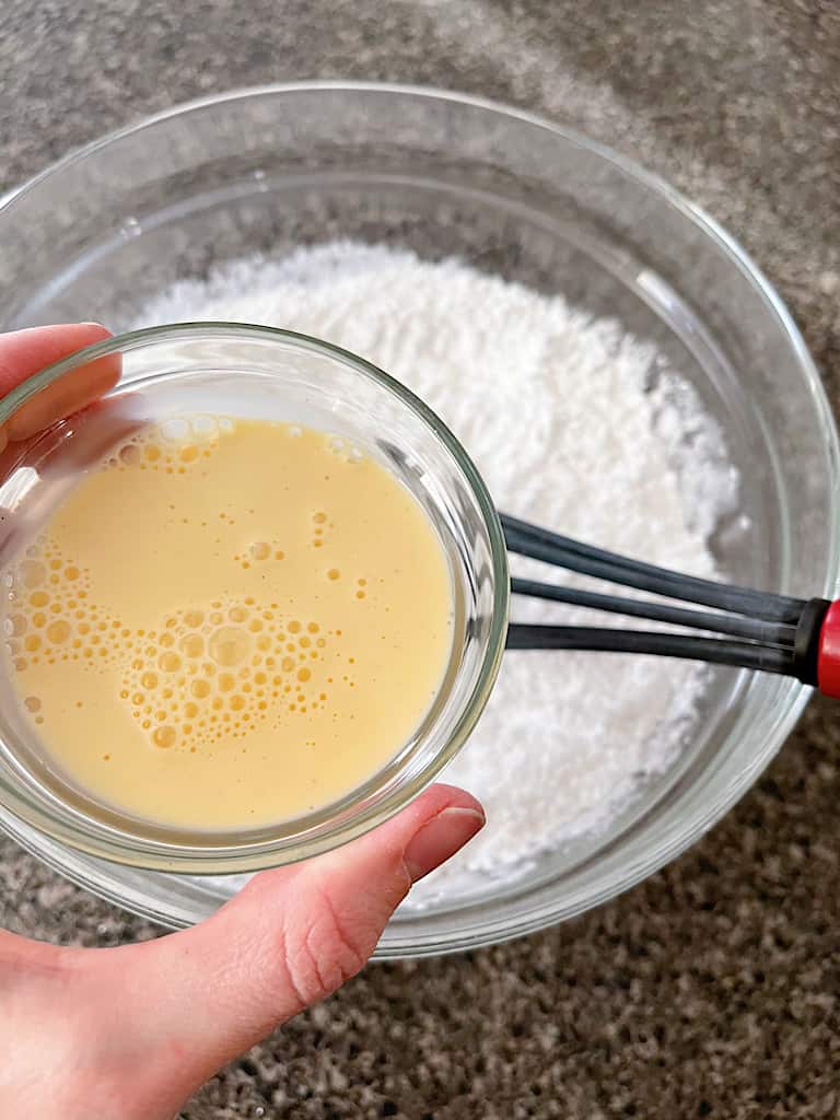 Use a silicone spatula to mix in the eggnog, starting with 3 tablespoons and adding more as needed, until combined.