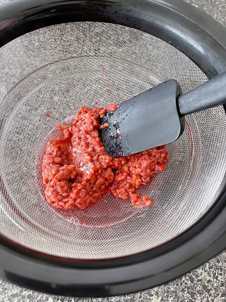 Use a spatula to push the juice out of the raspberries.