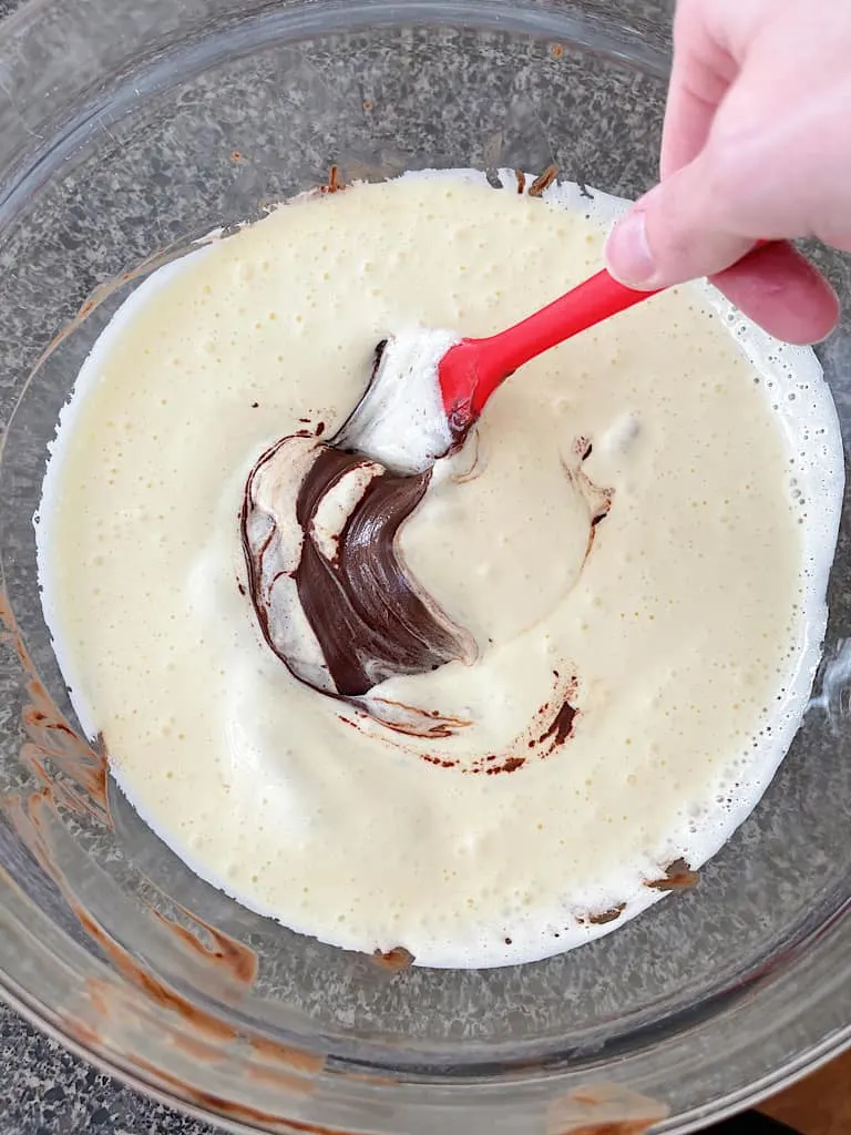 Use a silicone spatula to fold the egg mixture into the melted chocolate.