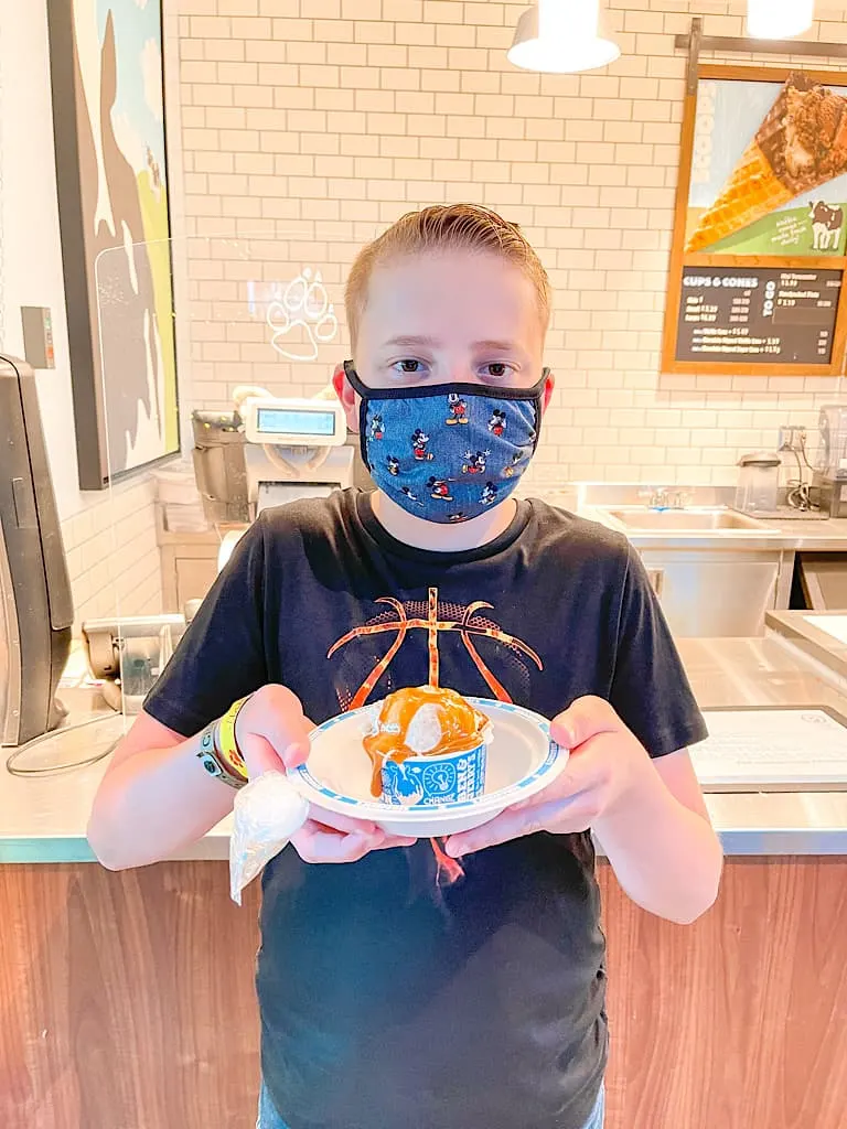 A boy with a mask holding a scoop of ice cream included with a Wolf Pass at Great Wolf Lodge
