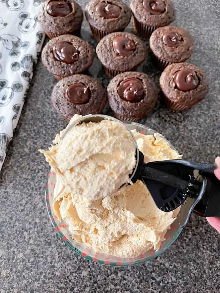 Use a cookie/ice cream scoop, about 1/4 cup, to scoop peanut butter frosting on to each cupcake.