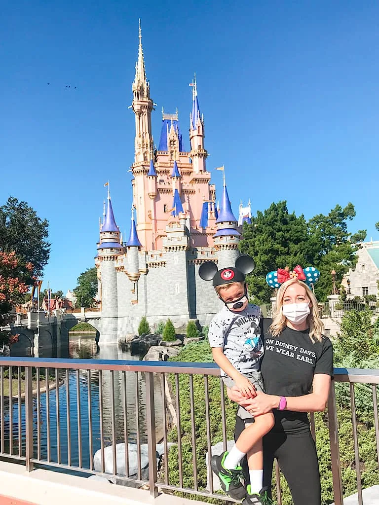 A mom and child in front of Cinderella's Castle