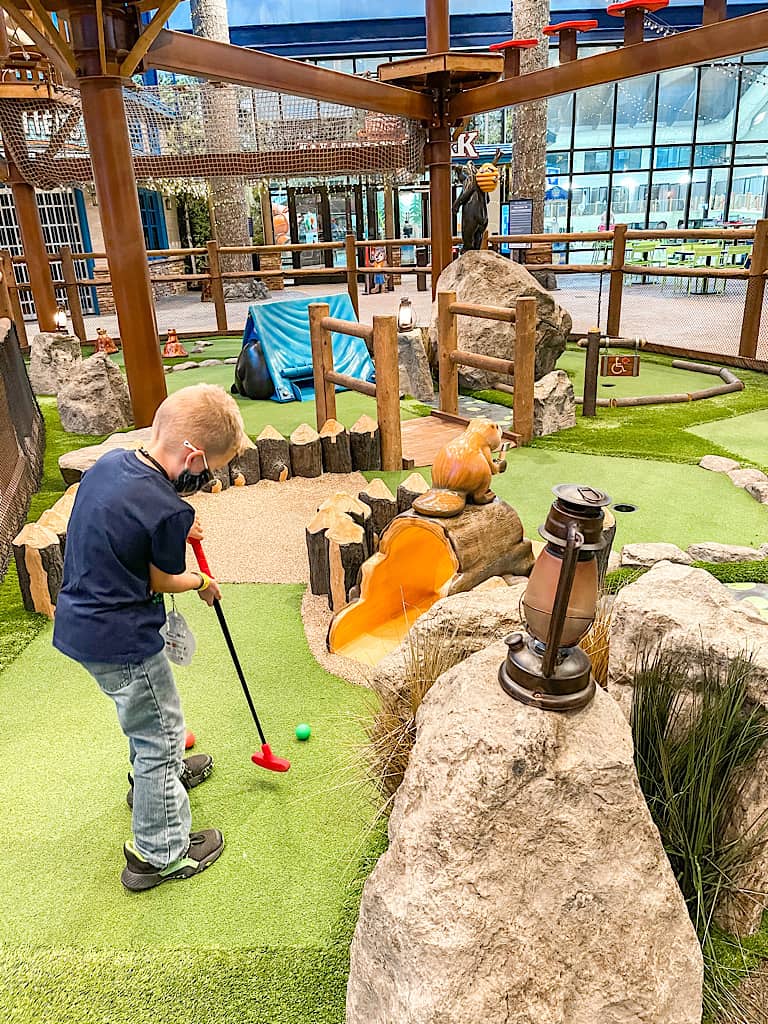 A boy playing mini golf at Great Wolf Lodge