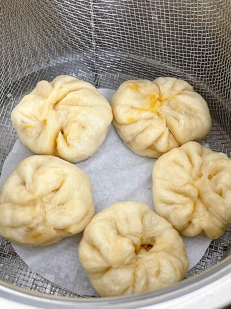 Steamed Cheeseburger Pods in a steamer basket.