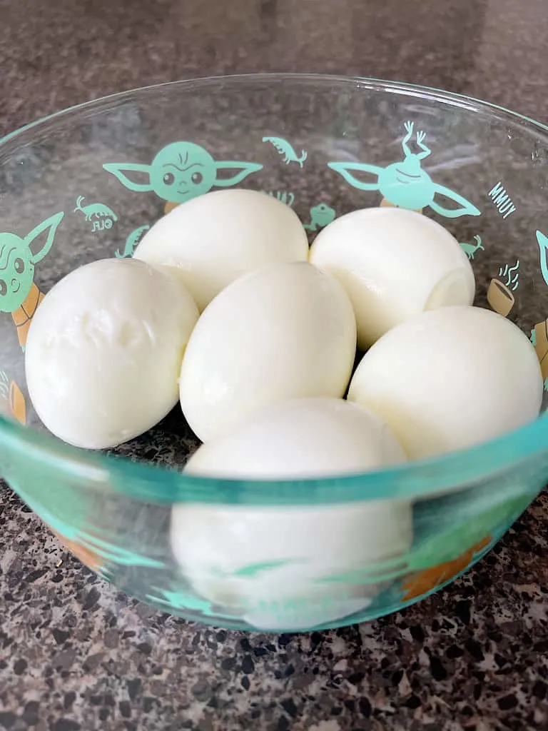 A bowl of peeled, hard boiled eggs.
