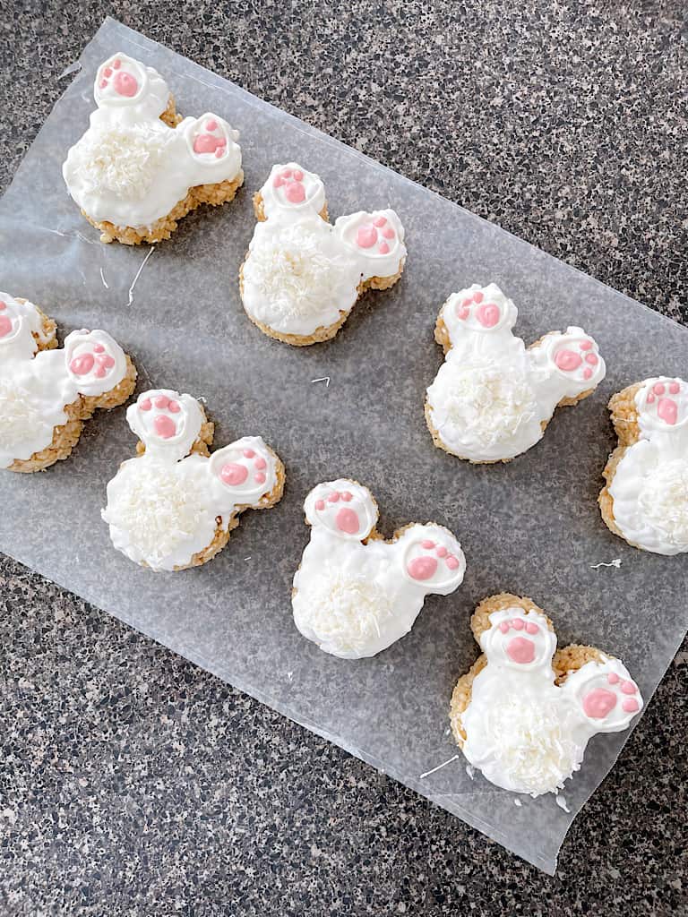 Eight Mickey Bunny Tail Rice Krispie Treats on Wax Paper.