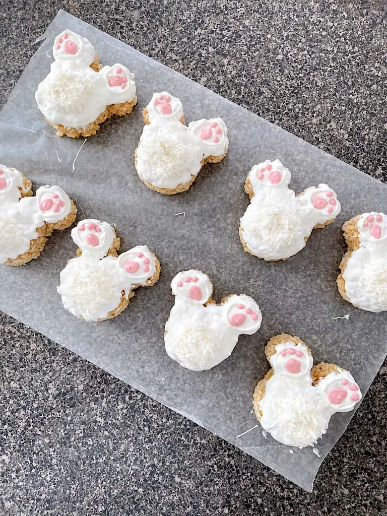 Eight Mickey Bunny Tail Rice Krispie Treats on Wax Paper.