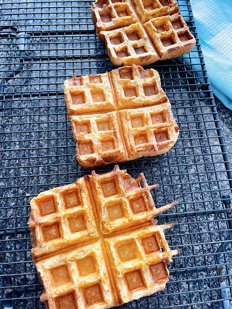 Three French Toast Waffles on a cooling rack.