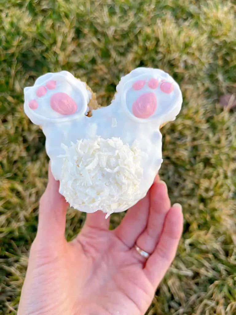 A hand holding a Mickey Mouse shaped Bunny Tail Rice Krispie Treat.