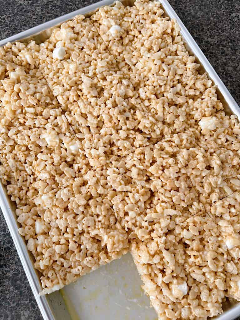 A pan of Rice Krispie Treats with one treat removed.