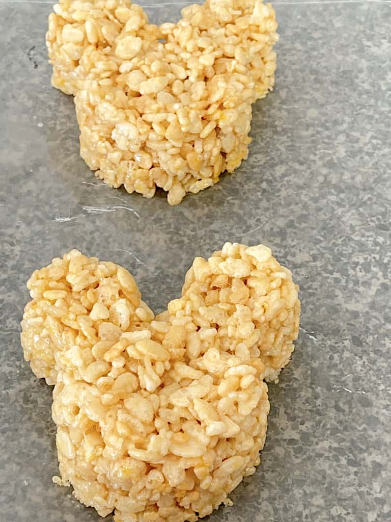 Two Mickey Mouse Rice Krispie Treats on wax paper.