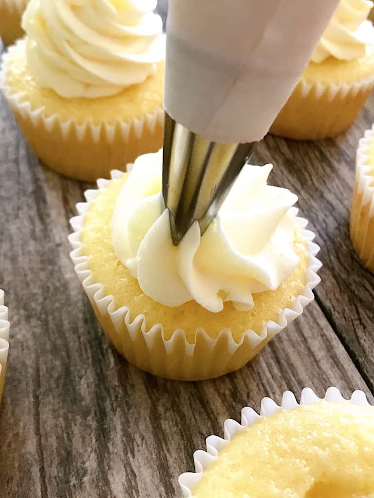 Pineapple buttercream being piped onto a pineapple cupcake.