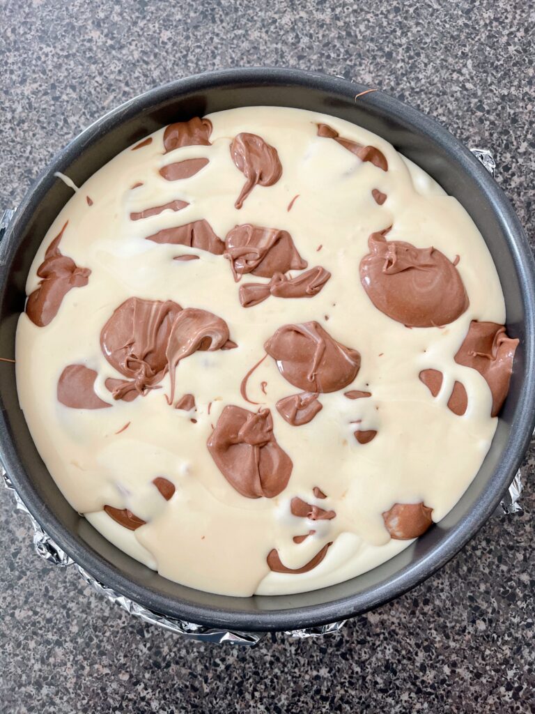 Chocolate and caramel cheesecake batter marbled with cheesecake.