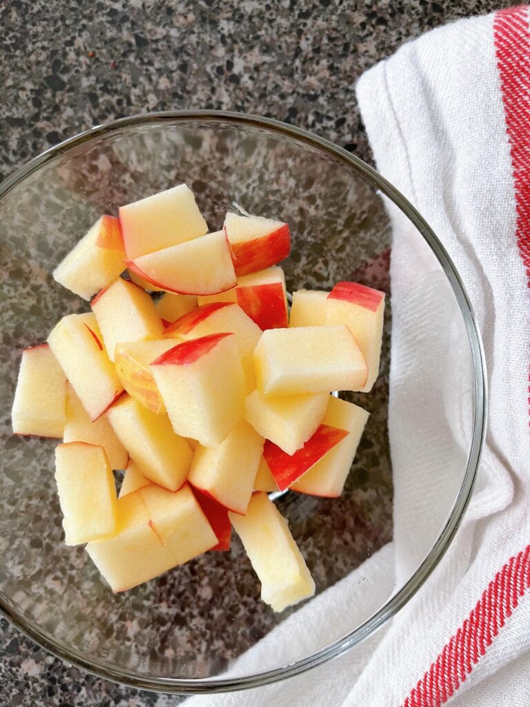 A bowl with a cut up Honeycrisp apple.