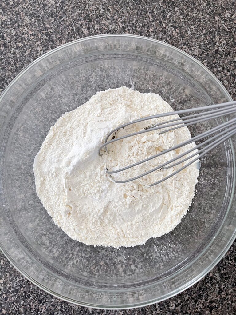 A bowl of dry ingredients and a whisk.