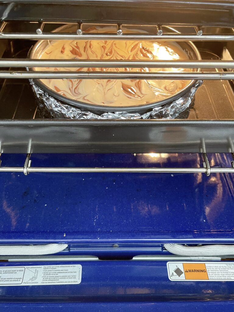 Cheesecake baking in an oven.