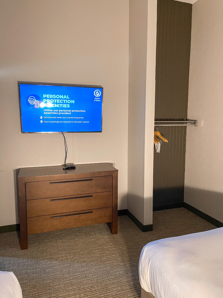 Closet, dresser, and television in the two queen bedroom of a Grizzly Bear Suite.