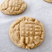 Freshly baked peanut butter cookies on parchment paper.