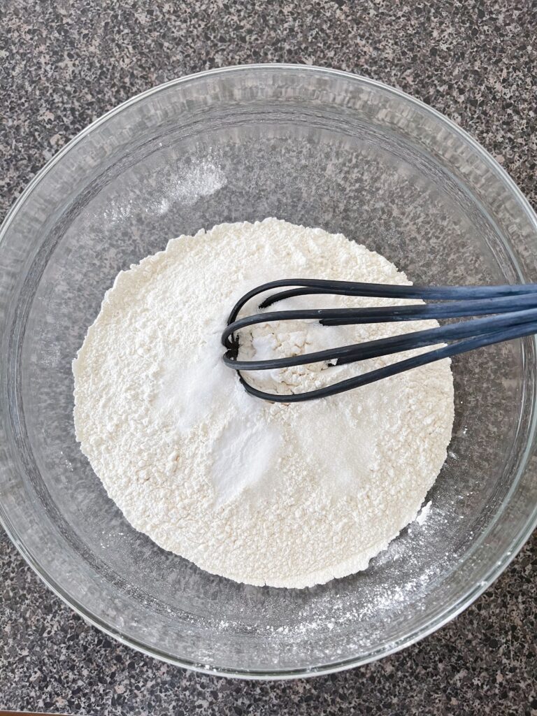 Flour in a bowl with a whisk.
