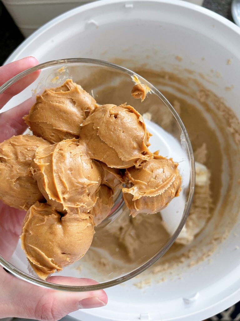 A bowl of peanut butter and a bowl of cookie dough.