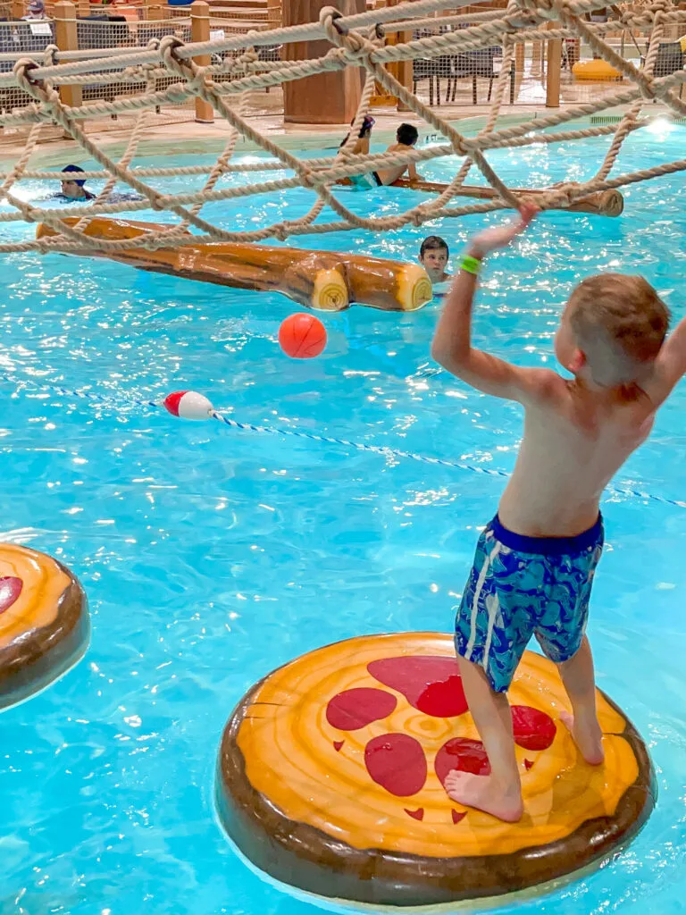 A boy climbing on lilly pads at Great Wolf Lodge.