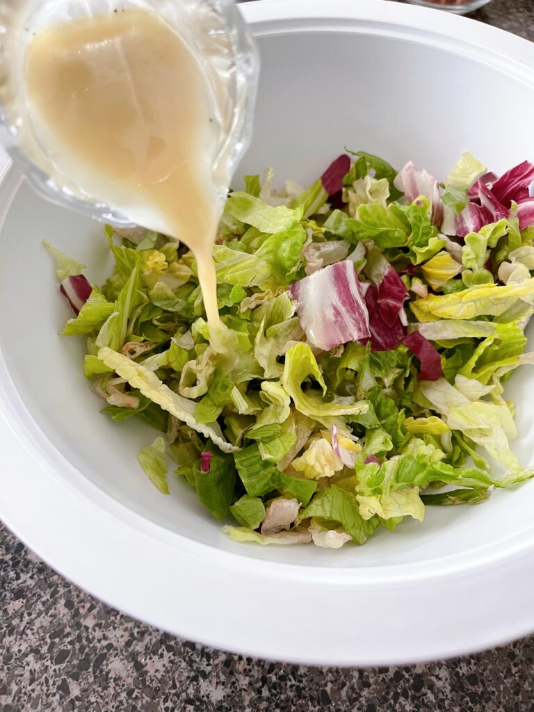 Apple cider vinaigrette drizzled over lettuce.