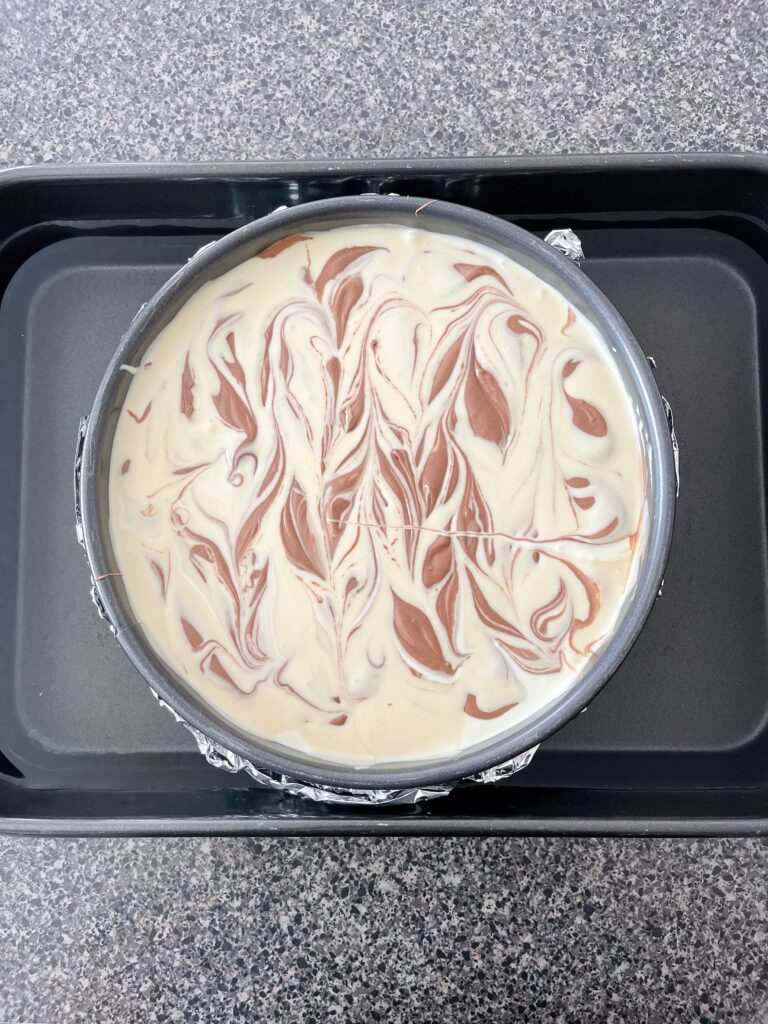 Caramel Pecan Cheesecake in a water bath.