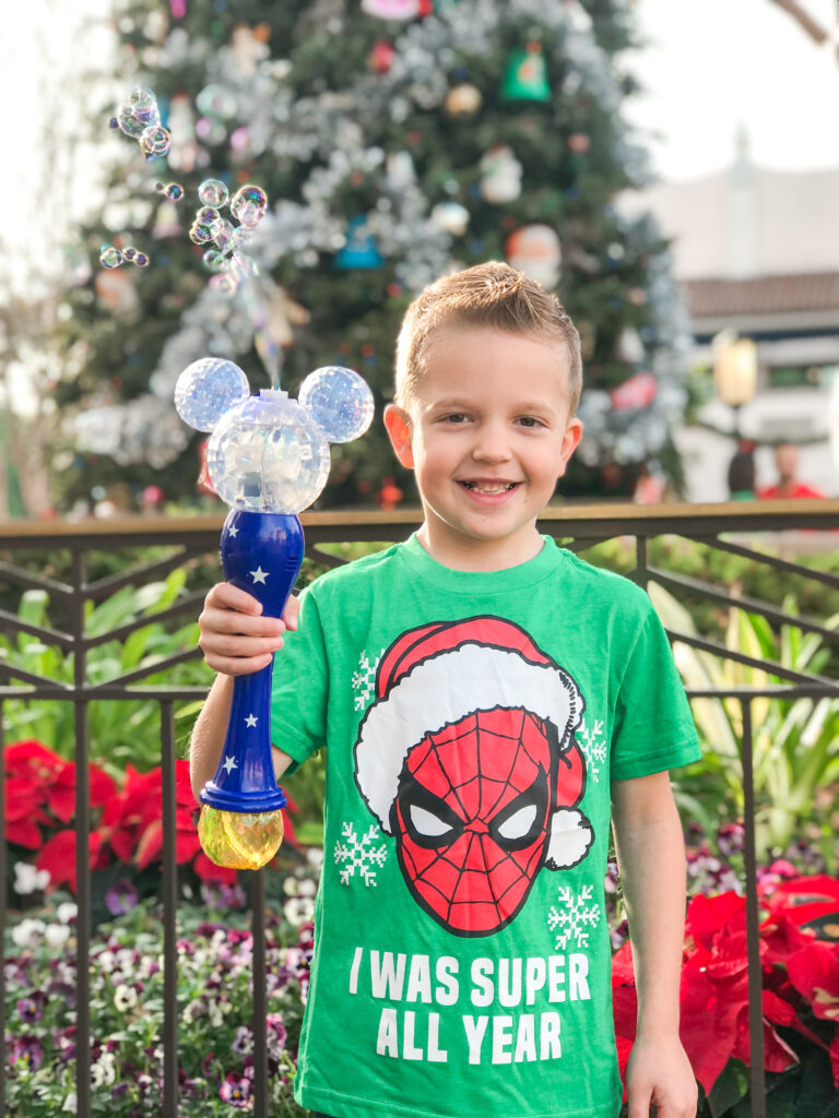 een jongen in Disneyland met een Mickey Mouse bubble toverstaf.