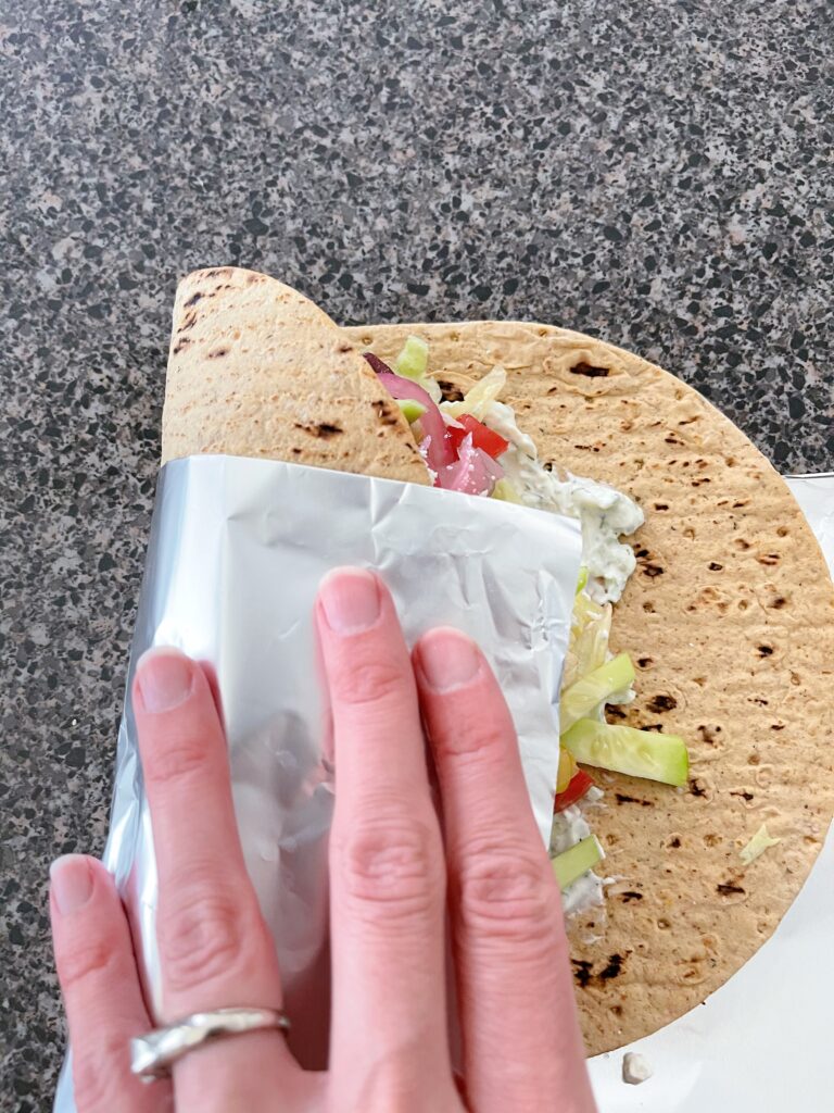 A veggie gyro being rolled up.