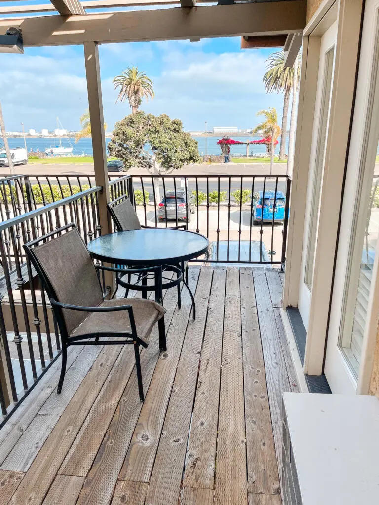 Deck with two chairs and a table with a view of San Diego Bay.