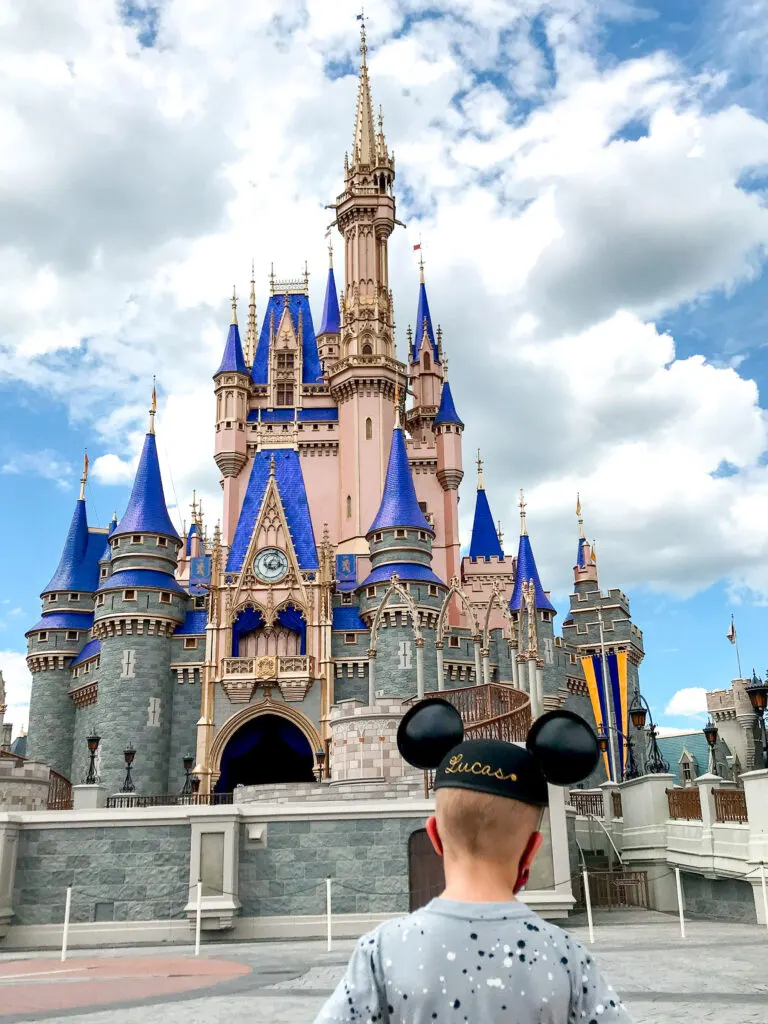 A boy in Mickey Ears in front of Cinderella Castle.