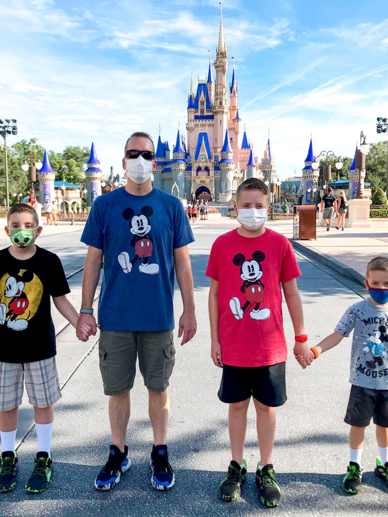 4 pessoas em frente ao Castelo da Cinderela em camisas do Mickey Mouse.