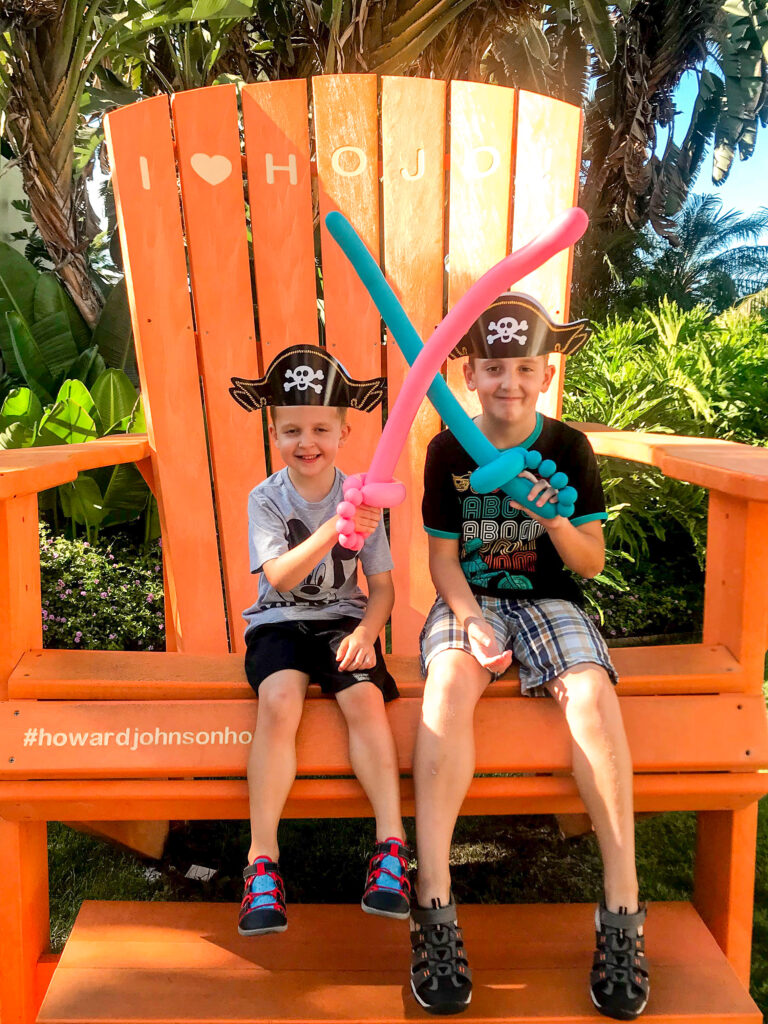 Two kids on a giant orange chair at Howard Johnson Anaheim.