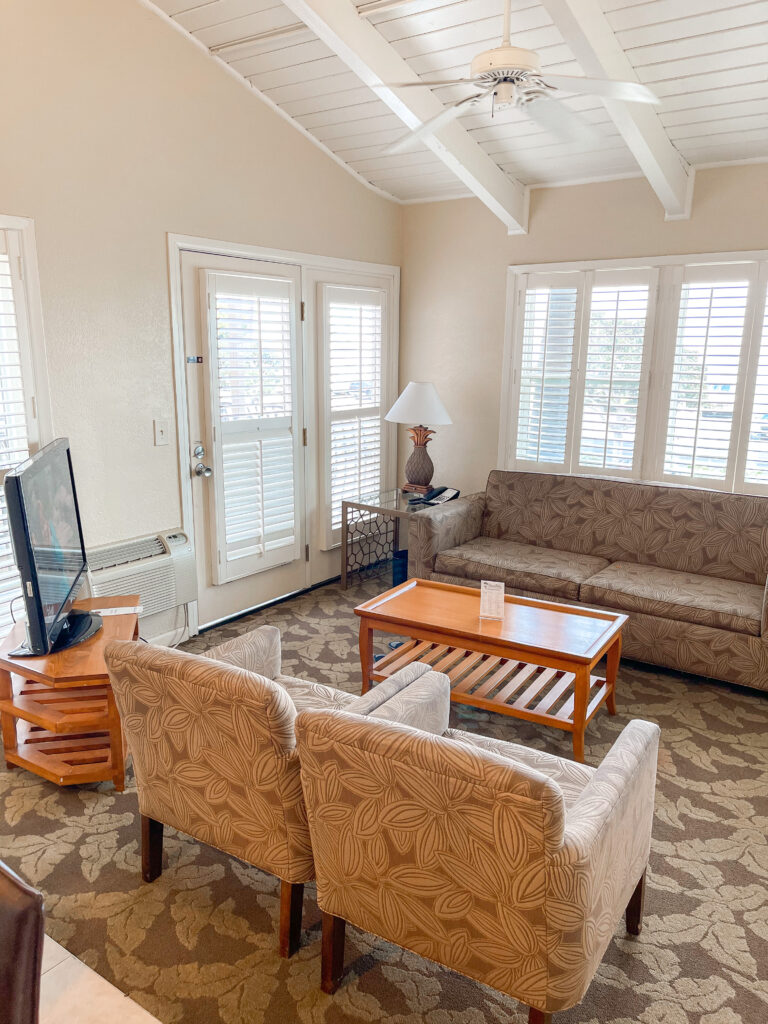 Living room with a couch, two chairs, tv, and a coffee table at Best Western Island Palms in San Diego.