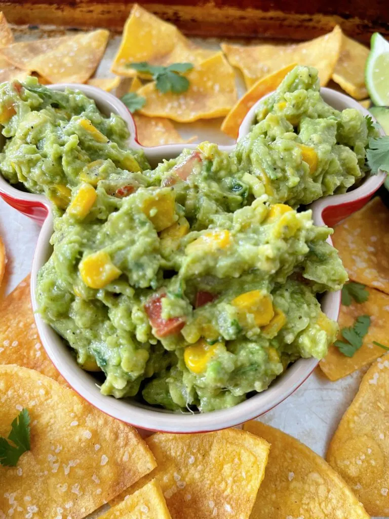 A close up picture of chunky guacamole in a Mickey Mouse-shaped bowl.