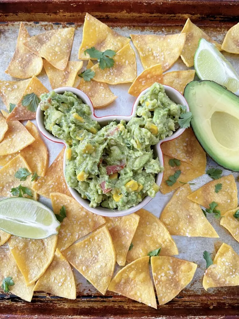 A Mickey Mouse shaped bowl of chunky guacamole.