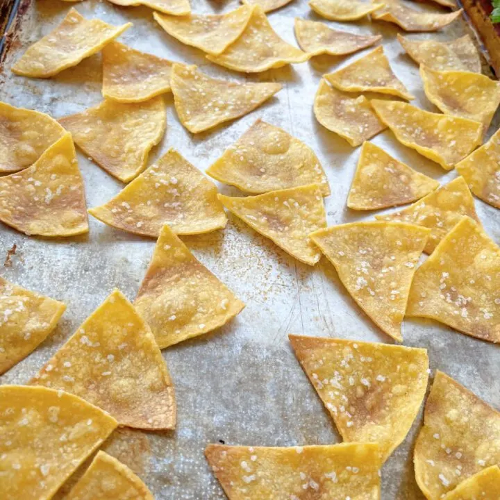 Baked tortilla chips on a pan.