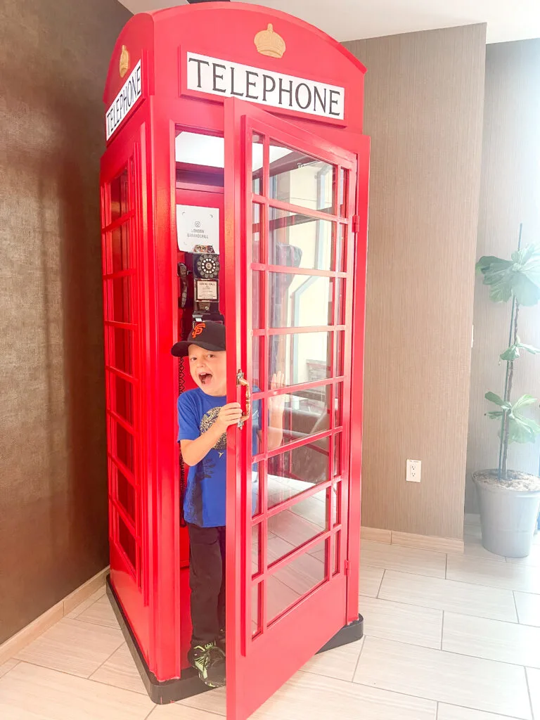 A boy in a red phone booth in San Francisco, California.