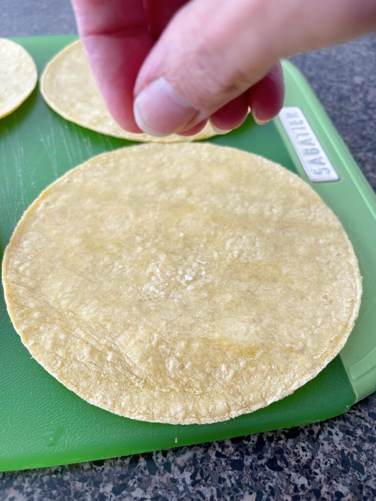 Sprinkling salt on a corn tortilla.