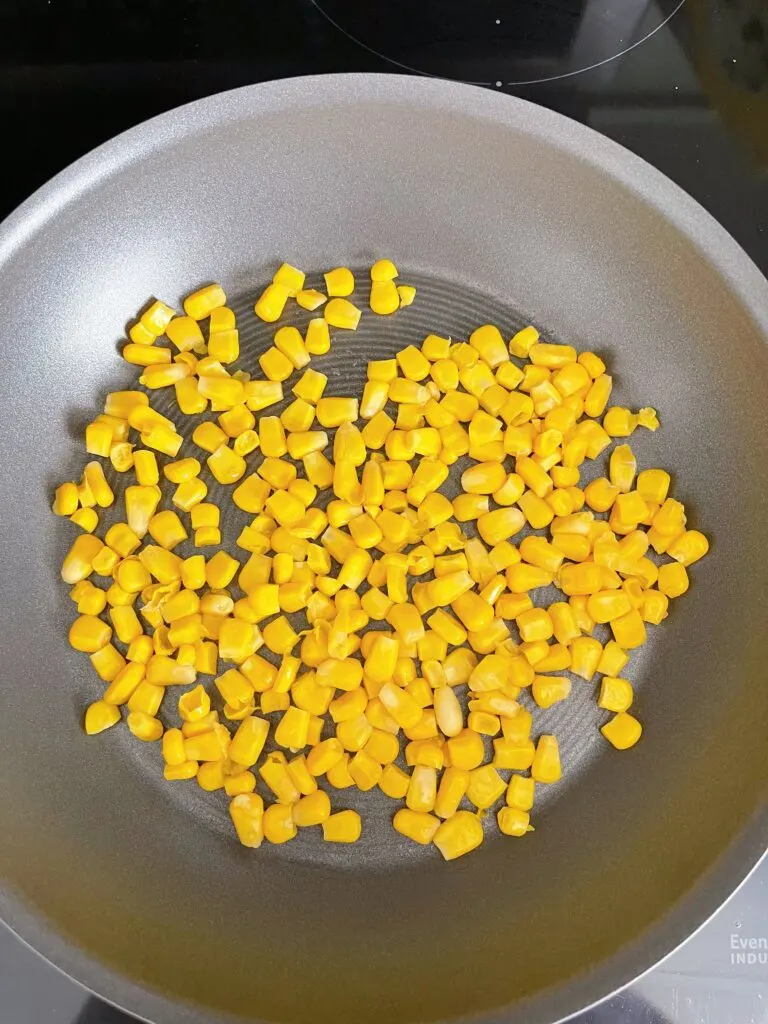 Corn roasting in a pan.