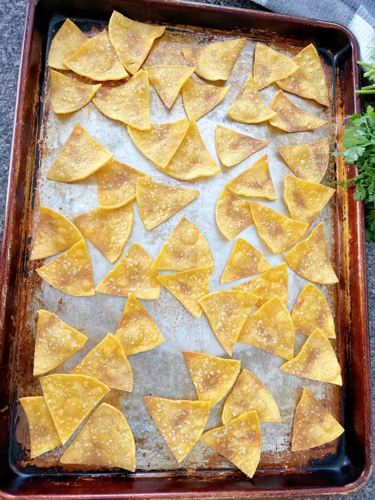 Baked tortilla chips on a pan.
