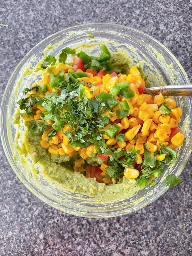 Chunky guacamole ingredients in a bowl.